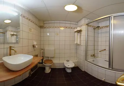 a bathroom with a sink and a toilet and a tub at Hotel Spaander BW Signature Collection in Volendam