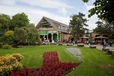 a building with a garden with flowers in the grass at Van der Valk Hotel Avifauna in Alphen aan den Rijn