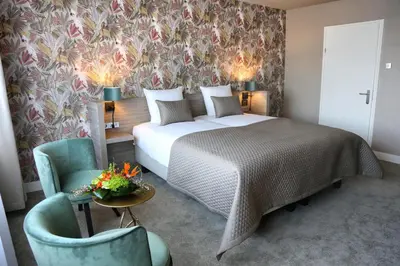 a hotel room with a bed and two chairs at Van der Valk Hotel Avifauna in Alphen aan den Rijn