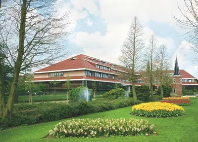 a building with a bunch of flowers in front of it at Van der Valk Hotel Avifauna in Alphen aan den Rijn