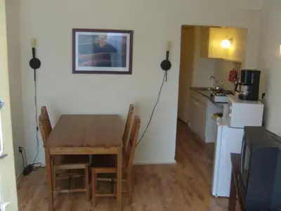 a dining room with a table and a kitchen at Badhotel Zeecroft in Wijk aan Zee