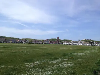a field of grass with a town in the background at Badhotel Zeecroft in Wijk aan Zee