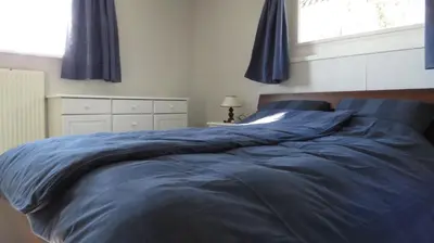a bed with a blue comforter in a bedroom at gouwzicht in Amsterdam