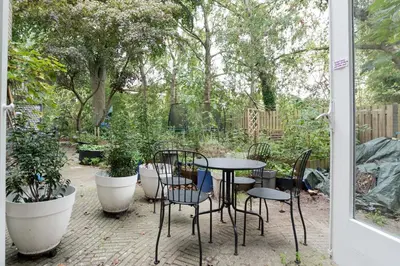 a patio with a table and chairs and plants at B&B Amsterdam West in Amsterdam