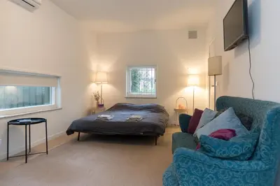 a living room with a bed and a blue couch at B&B Amsterdam West in Amsterdam