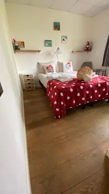 a bedroom with two beds with red and white sheets at Hotel 1900 in Bergen