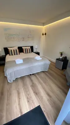a bedroom with a large bed and wooden floors at Hotel 1900 in Bergen