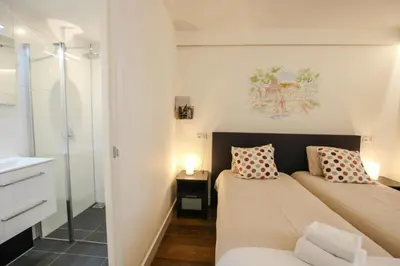 a small bedroom with two beds and a bathroom at Hotel 1900 in Bergen