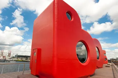 a red building with round windows on a boat at Botel in Amsterdam