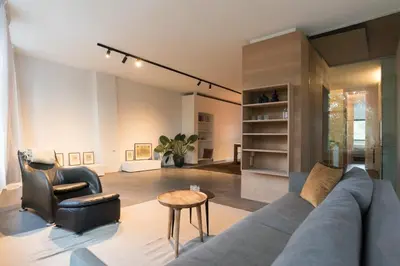 a living room with a blue couch and a chair at City centre Loft on the historic Canal in Utrecht