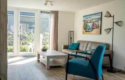 a living room with a couch and a table at Bungalow 71 op Recreatiepark De Wielen in Sint Maarten
