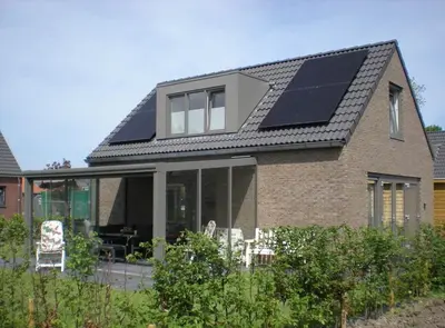 a house with solar panels on the roof at Bungalow 71 op Recreatiepark De Wielen in Sint Maarten
