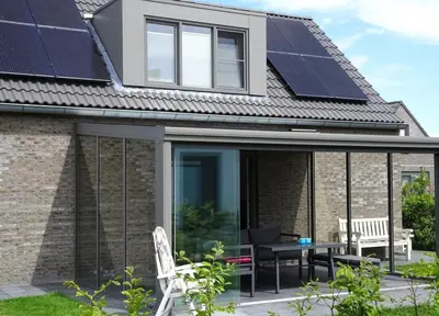 a house with solar panels on the roof at Bungalow 71 op Recreatiepark De Wielen in Sint Maarten