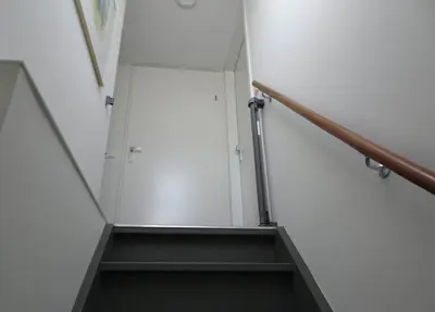 a stairway with a white wall and a white door at Bungalow 71 op Recreatiepark De Wielen in Sint Maarten