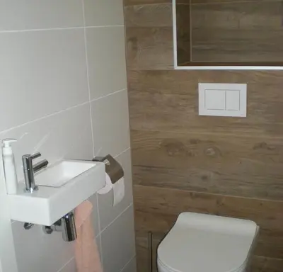 a bathroom with a white sink and a toilet at Bungalow 71 op Recreatiepark De Wielen in Sint Maarten