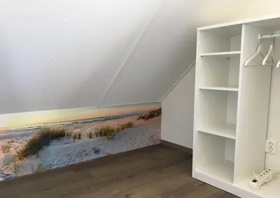 a room with a painting of the beach on the wall at Bungalow 71 op Recreatiepark De Wielen in Sint Maarten