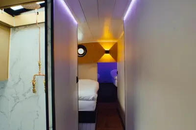 a small room with a bed and a hallway at Unieke beleving op het water, de Prinsenboot. in Spaarndam
