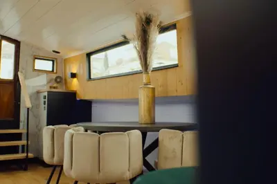 a dining room with a table and some chairs at Unieke beleving op het water, de Prinsenboot. in Spaarndam