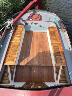 a boat with a wooden deck in the water at Unieke beleving op het water, de Prinsenboot. in Spaarndam