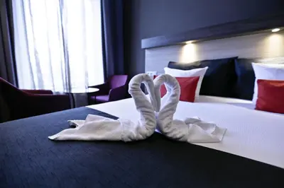 two towel swans sitting on a bed in a hotel room at City Hotel Amsterdam in Amsterdam