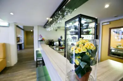 a vase filled with yellow flowers sitting on a counter at City Hotel Amsterdam in Amsterdam