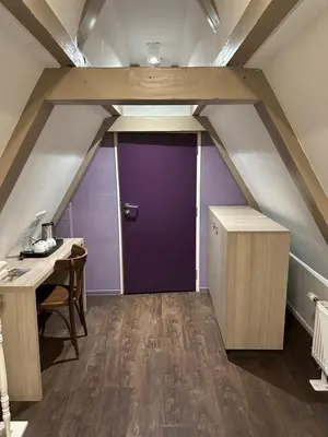 a room with a purple door in an attic at City Hotel Amsterdam in Amsterdam