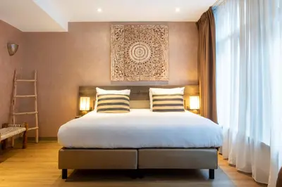a bedroom with a large bed with two pillows at Dream Hotel Amsterdam in Amsterdam
