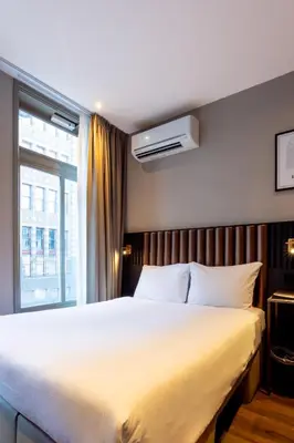 a bedroom with a large white bed and a window at Dream Hotel Amsterdam in Amsterdam
