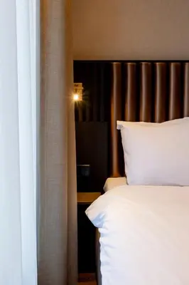 a bedroom with a bed with white pillows at Dream Hotel Amsterdam in Amsterdam