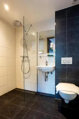a bathroom with a sink and a shower and a toilet at Dream Hotel Amsterdam in Amsterdam