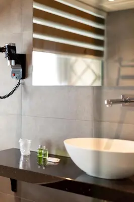 a bathroom counter with a white bowl on a sink at Dream Hotel Amsterdam in Amsterdam
