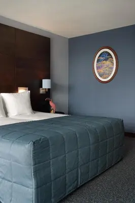 a bedroom with a large bed with a blue wall at Van der Valk Hotel Sassenheim - Leiden in Sassenheim