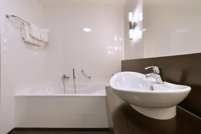 a white bathroom with a sink and a tub at Van der Valk Hotel Sassenheim - Leiden in Sassenheim