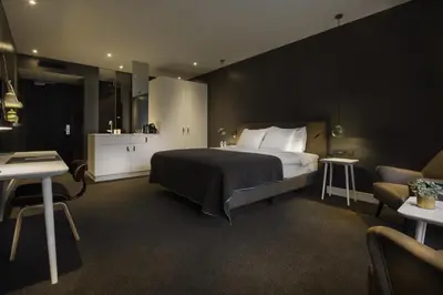 a hotel room with a bed and a chair at Van der Valk Hotel Sassenheim - Leiden in Sassenheim