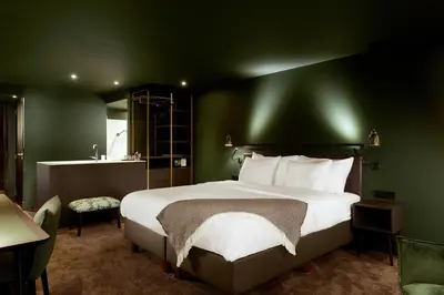 a bedroom with a large bed with a green wall at Van der Valk Hotel Sassenheim - Leiden in Sassenheim