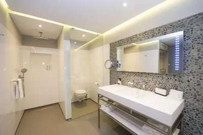 a bathroom with a sink and a toilet and a mirror at Van der Valk Hotel Sassenheim - Leiden in Sassenheim