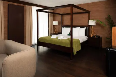 a bedroom with a canopy bed and a couch at Van der Valk Hotel Sassenheim - Leiden in Sassenheim