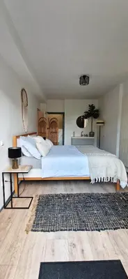 a bedroom with a large white bed and a rug at The West Wing Bloemendaal in Bloemendaal