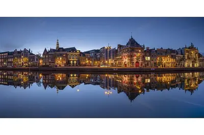 a city with its reflection in the water at night at The West Wing Bloemendaal in Bloemendaal
