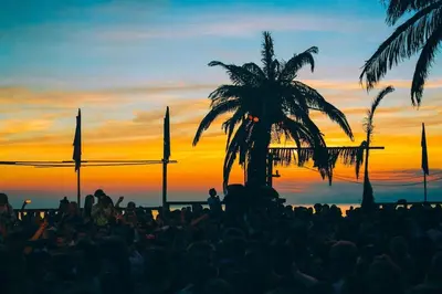 a crowd of people at a concert with a palm tree at The West Wing Bloemendaal in Bloemendaal