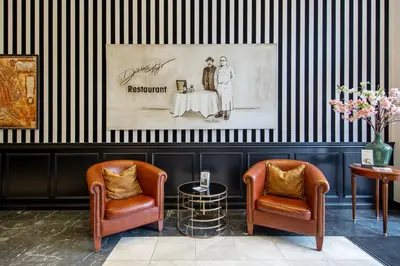 two chairs and a table in a room with black and white stripes at Dikker & Thijs Hotel in Amsterdam