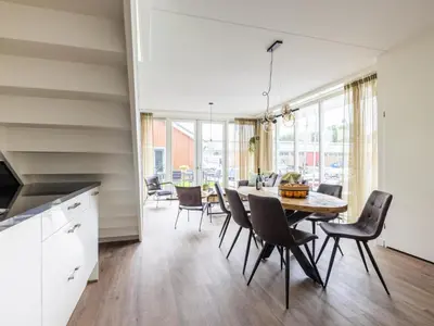 a kitchen and dining room with a table and chairs at Lakehouse I in Uitgeest