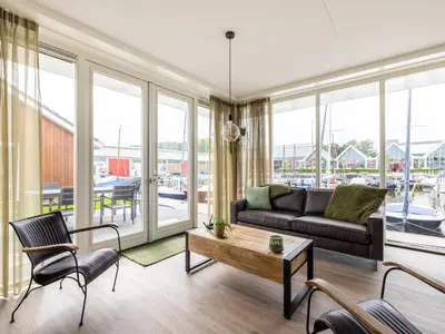 a living room with a couch and a table at Lakehouse I in Uitgeest