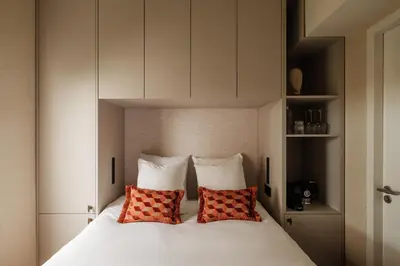 a bedroom with a white bed with two red pillows at House of Adam in Amsterdam