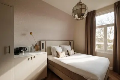 a bedroom with a large white bed with a window at House of Adam in Amsterdam