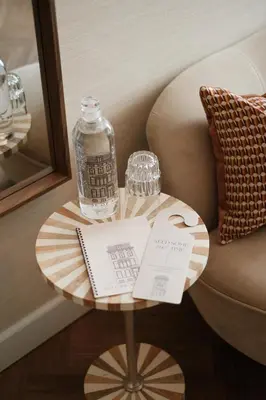 a table with a bottle and a glass on a couch at House of Adam in Amsterdam