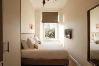 a bedroom with a bed and a window at House of Adam in Amsterdam