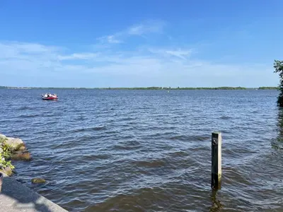 a boat in the middle of a large body of water at B&B De Tulpentoren in Roelofarendsveen
