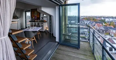 a balcony with a table and a view of a city at B&B De Tulpentoren in Roelofarendsveen