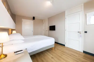 a bedroom with a bed and a desk with a lamp at B&B De Tulpentoren in Roelofarendsveen